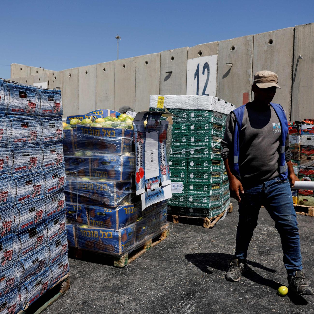 A man walks next to humanitarian aid destined for the Gaza Strip, amid the ongoing conflict in Gaza between Israel and Hamas.