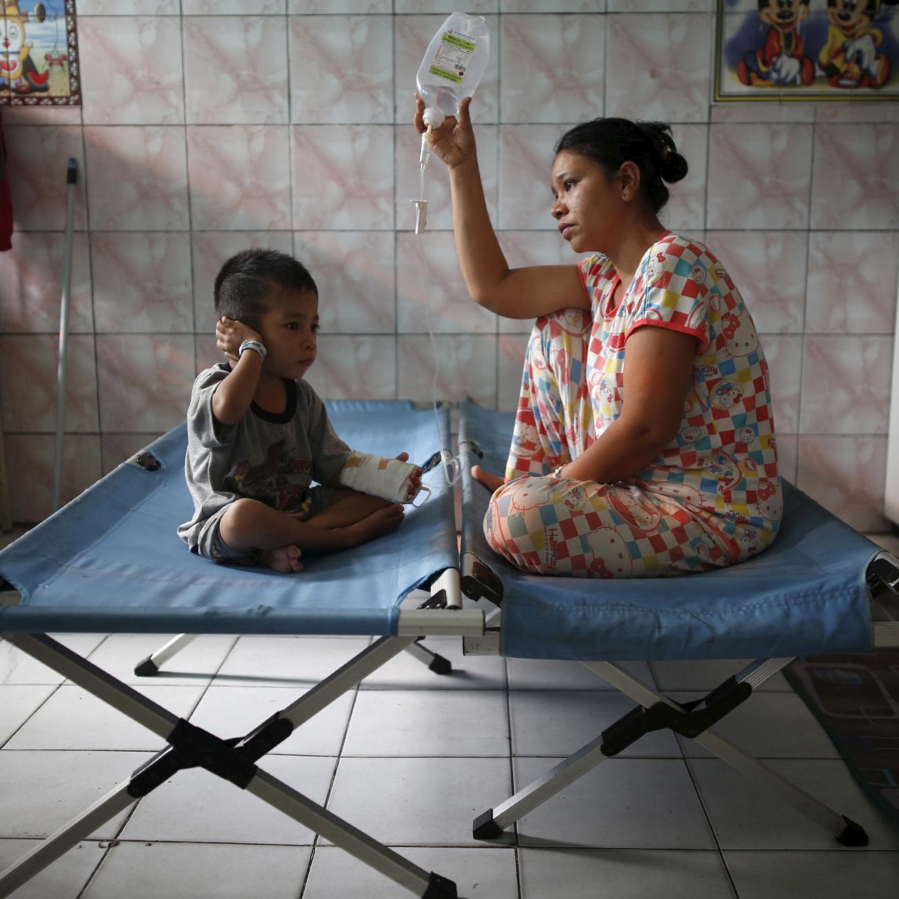 A mother sits with her son who is recovering from a respiratory illness in a hospital in Palangkaraya, Central Kalimantan, Indonesia October 28, 2015