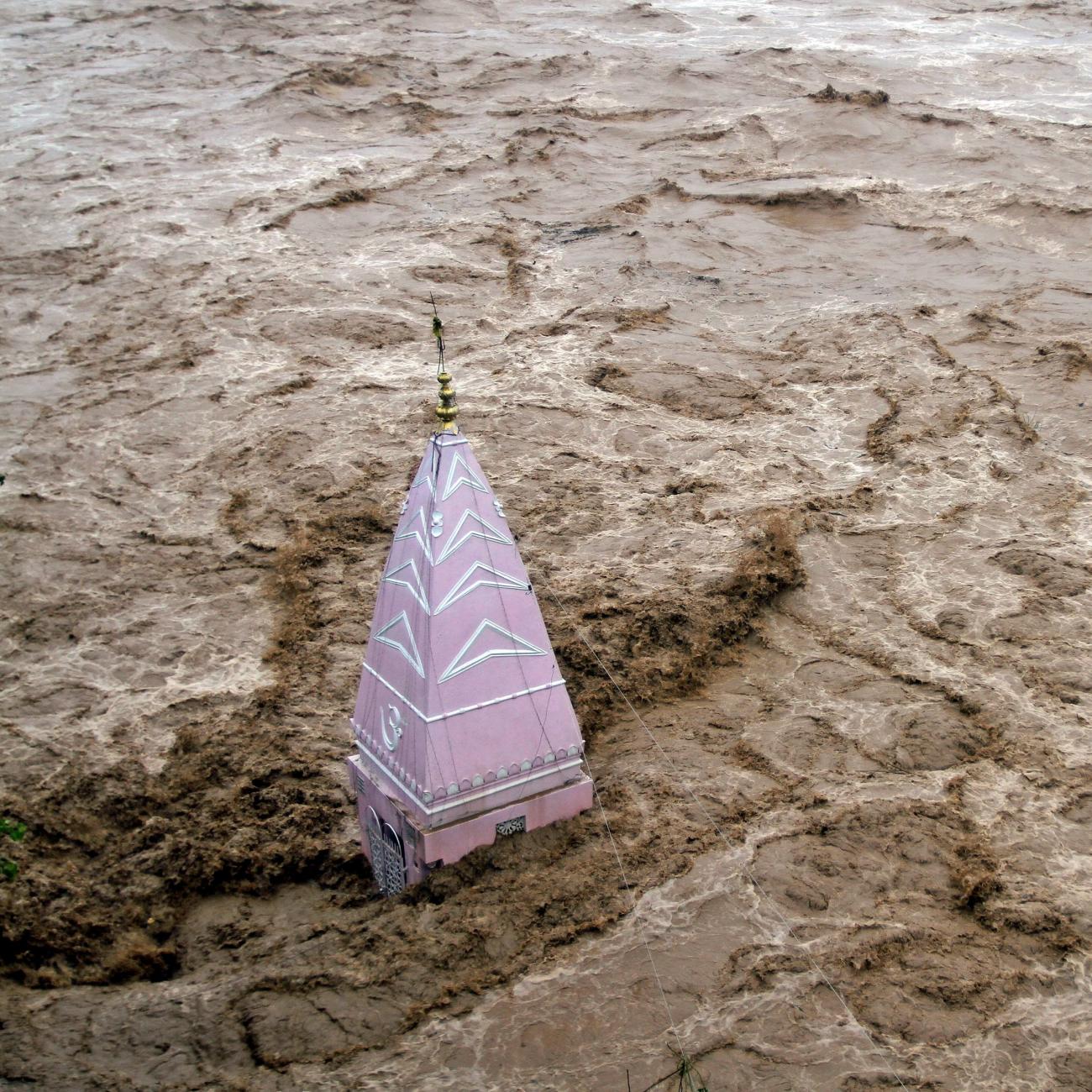 A temple stands amid the waters of the overflowing river Tawi during heavy rains in Jammu September 6, 2014. 