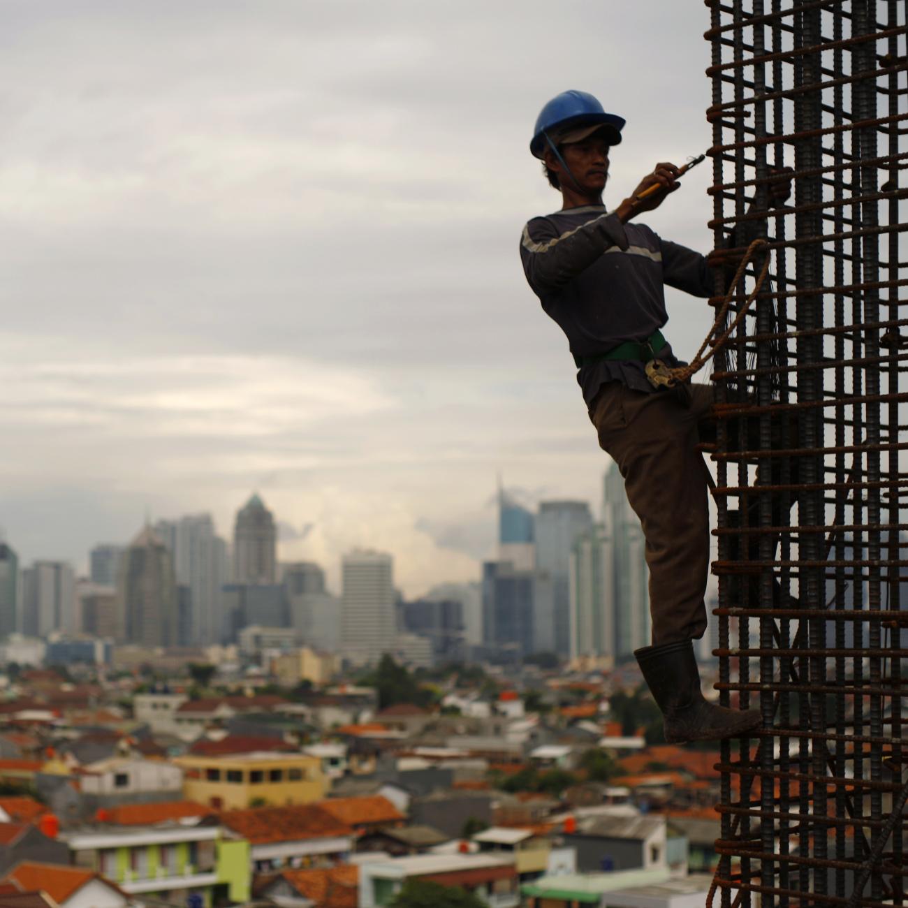 A worker stands on steel rods at a construction site, Jakarta, Indonesia, on February 2, 2010. 