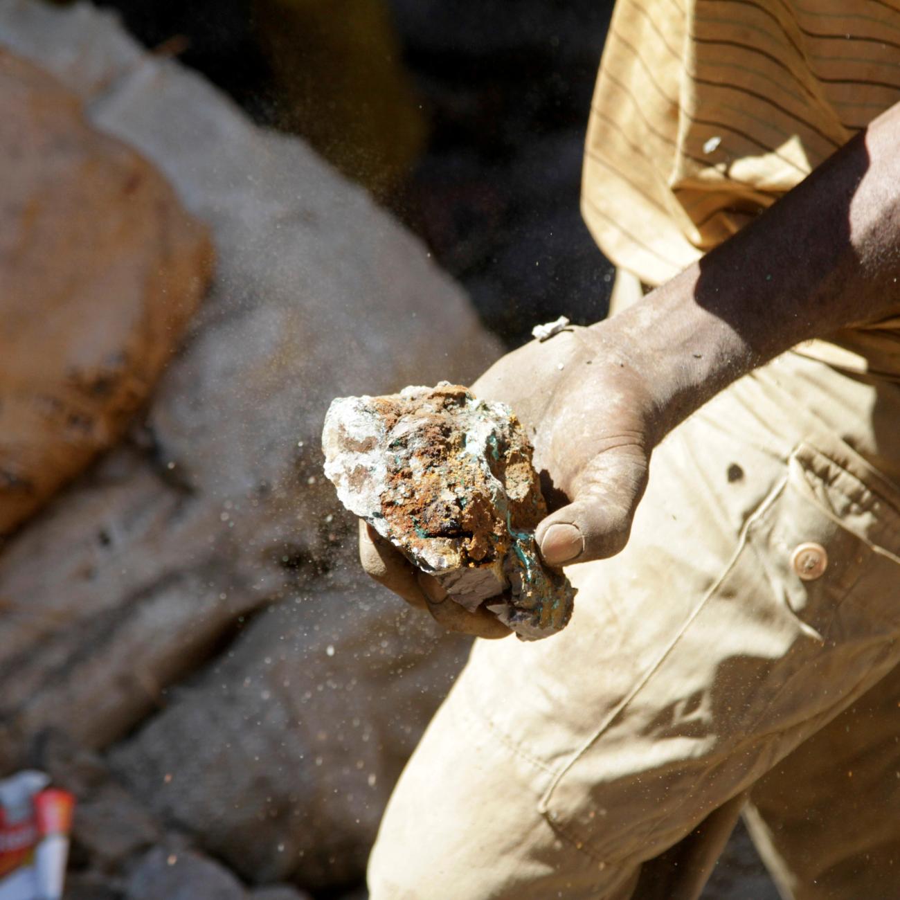An artisanal miner carries raw ore at Tilwizembe, a former industrial copper-cobalt mine, outside of Kolwezi, Democratic Republic of Congo, on June 11, 2016. 