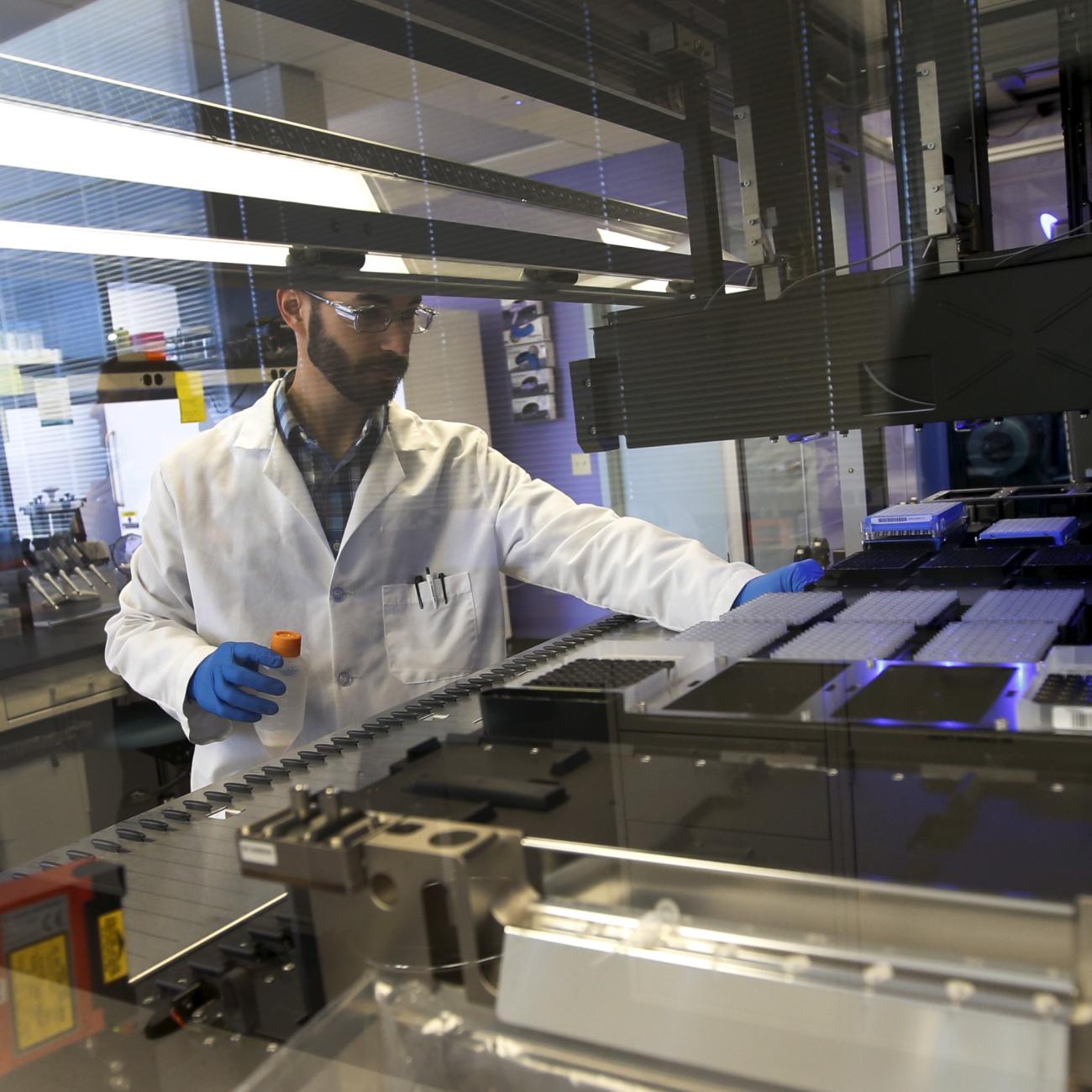 A technician loads a robotic DNA sample automation machine, at a Regeneron Pharmaceuticals Inc. Laboratory, in Tarrytown, New York, on March 24, 2015. 