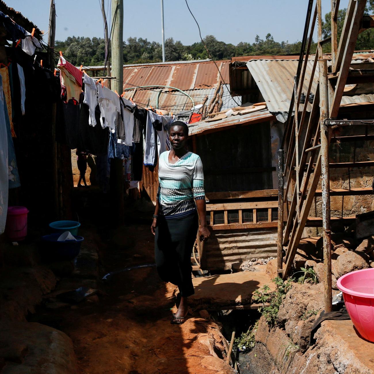 Alice Okwirry, 50, a widow living with HIV/AIDS, walks near her house, in Kianda village, Nairobi, Kenya, on February 28, 2025. 