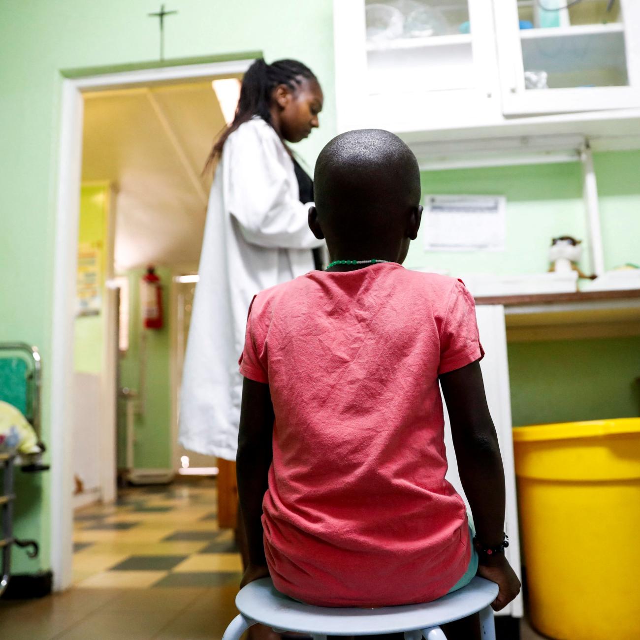 A child sits as a nurse prepares to dispense antiretroviral ARV drugs used to prevent HIV from replicating, at the Nyumbani Children's Home, Nairobi, Kenya, on February 12, 2025. 