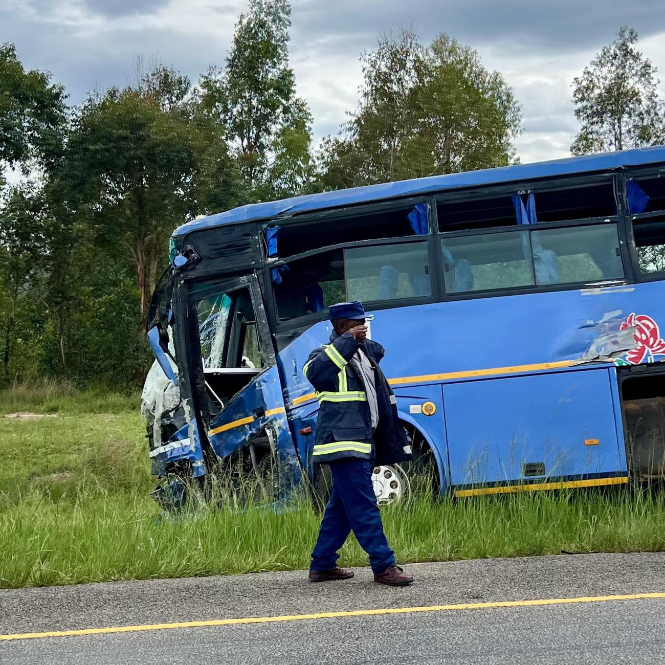A man walks away from a bus that was involved in a disastrous head-on collision with tractor-trailer, in Macheke, Zimbabwe, in January 2024. 
