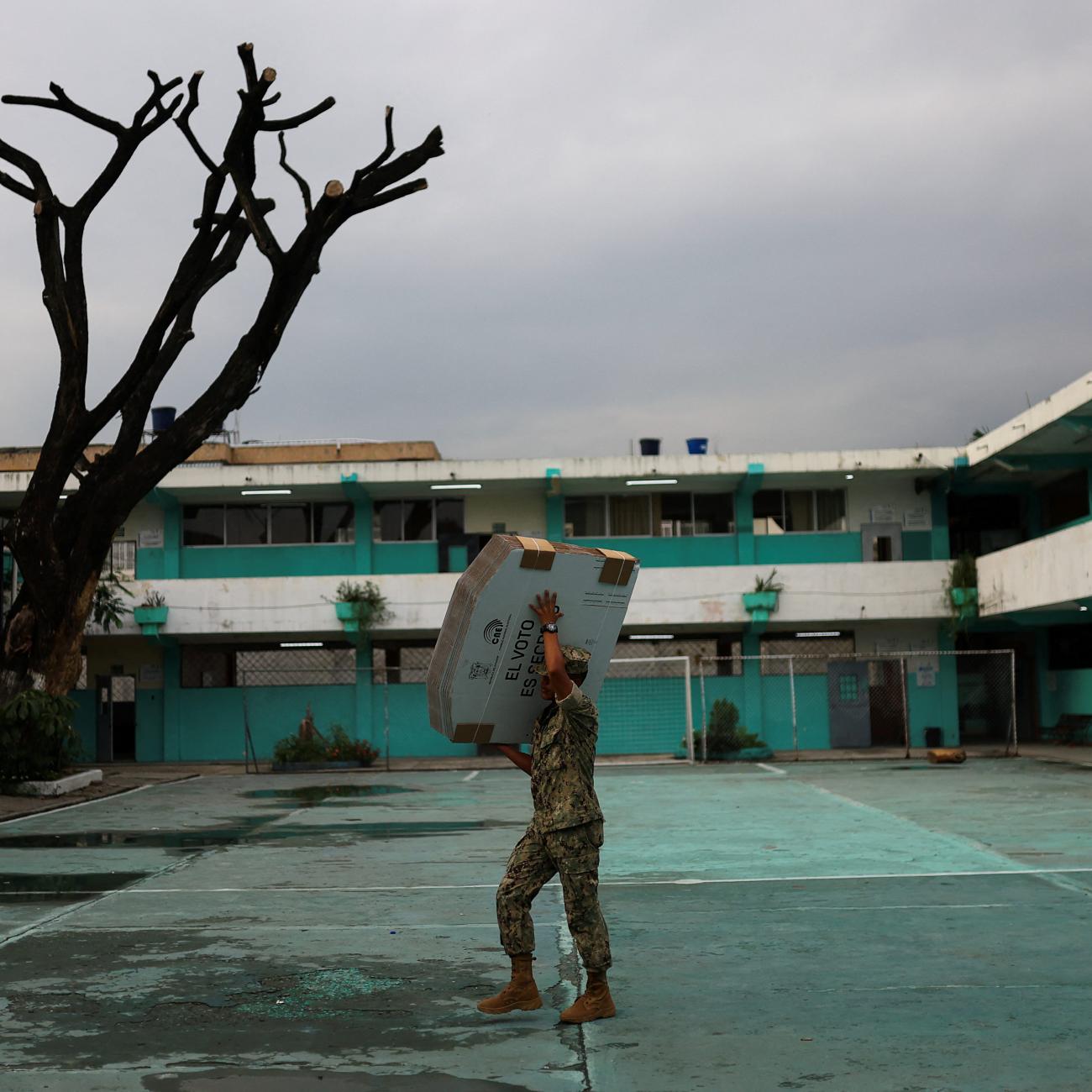 A member of the Navy carries electoral material out to a school that is being used a polling station ahead of the presidential election, in Guayaquil, Ecuador, on February 8, 2025. 