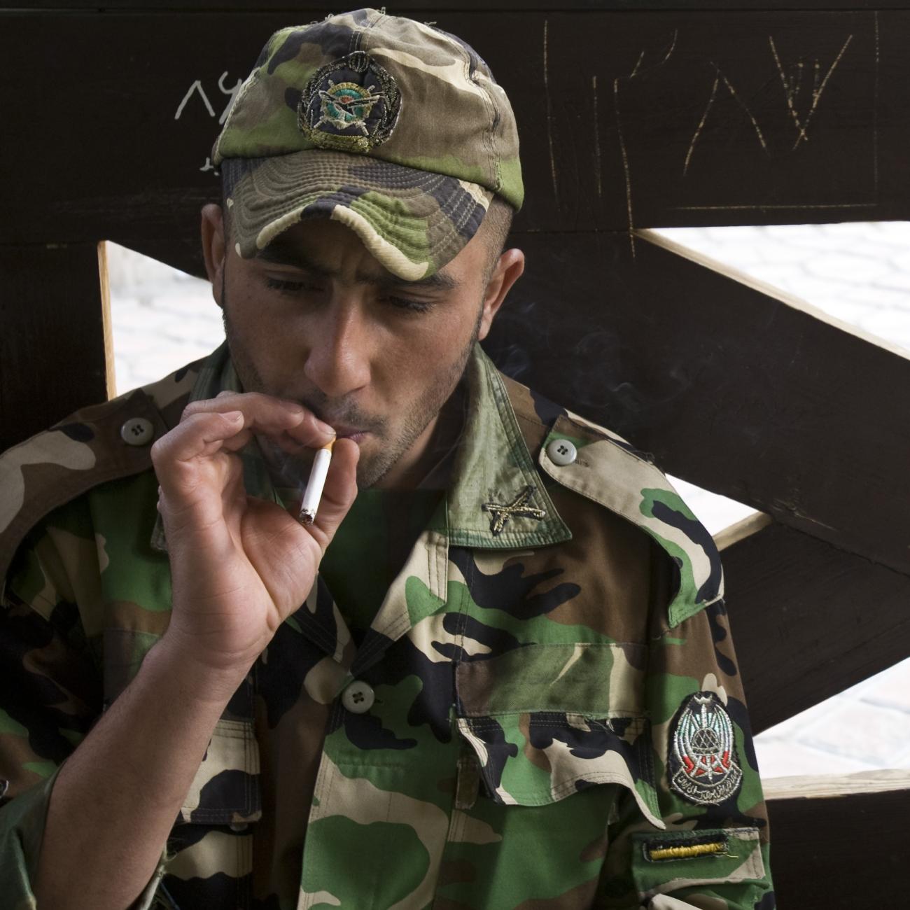 A member of the Iranian army smokes as he rests at a park in central Tehran, April 9, 2009