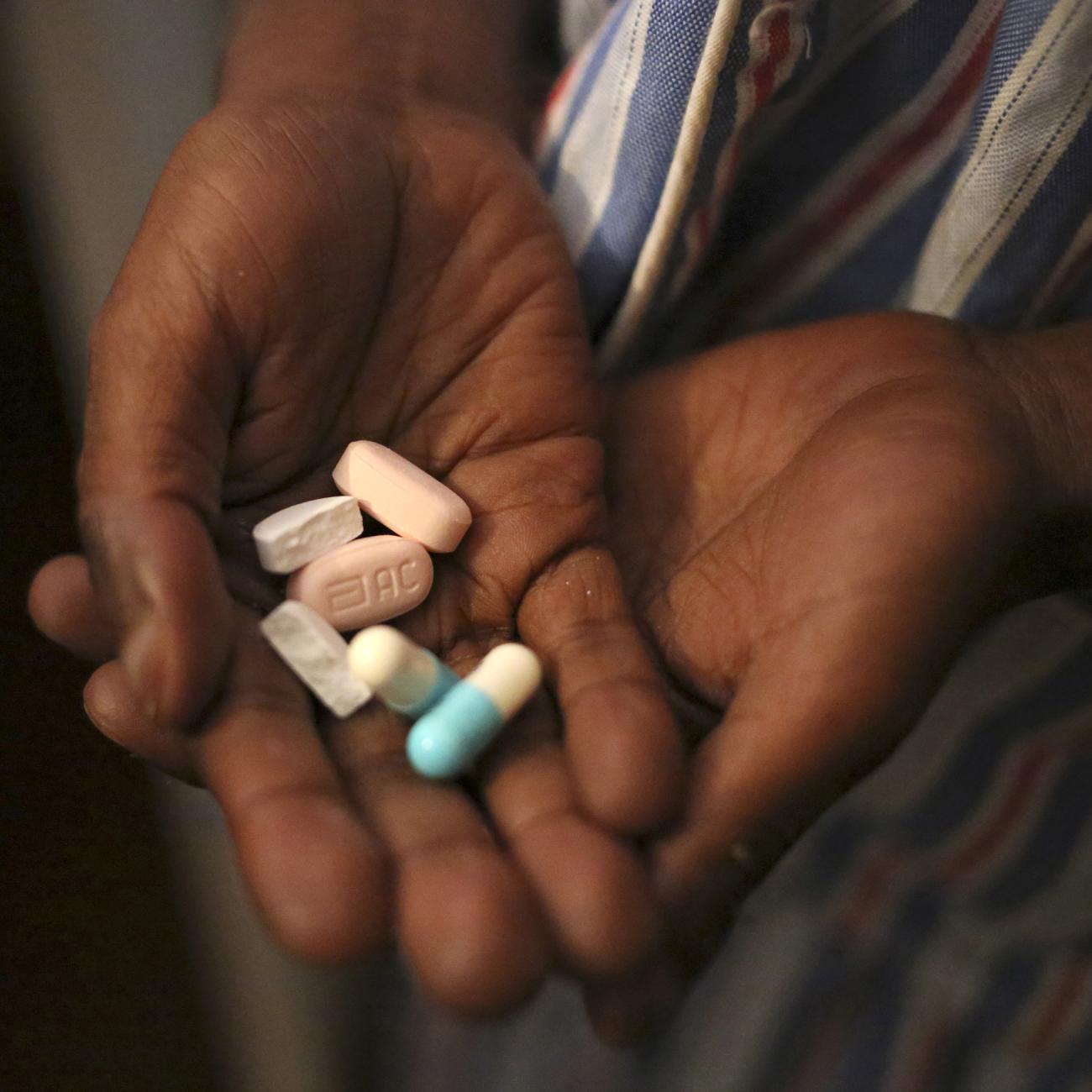 A boy holds a handful of antiretroviral pills before taking his medication at Nkosi's Haven, in Johannesburg, South Africa, on November 28, 2014.