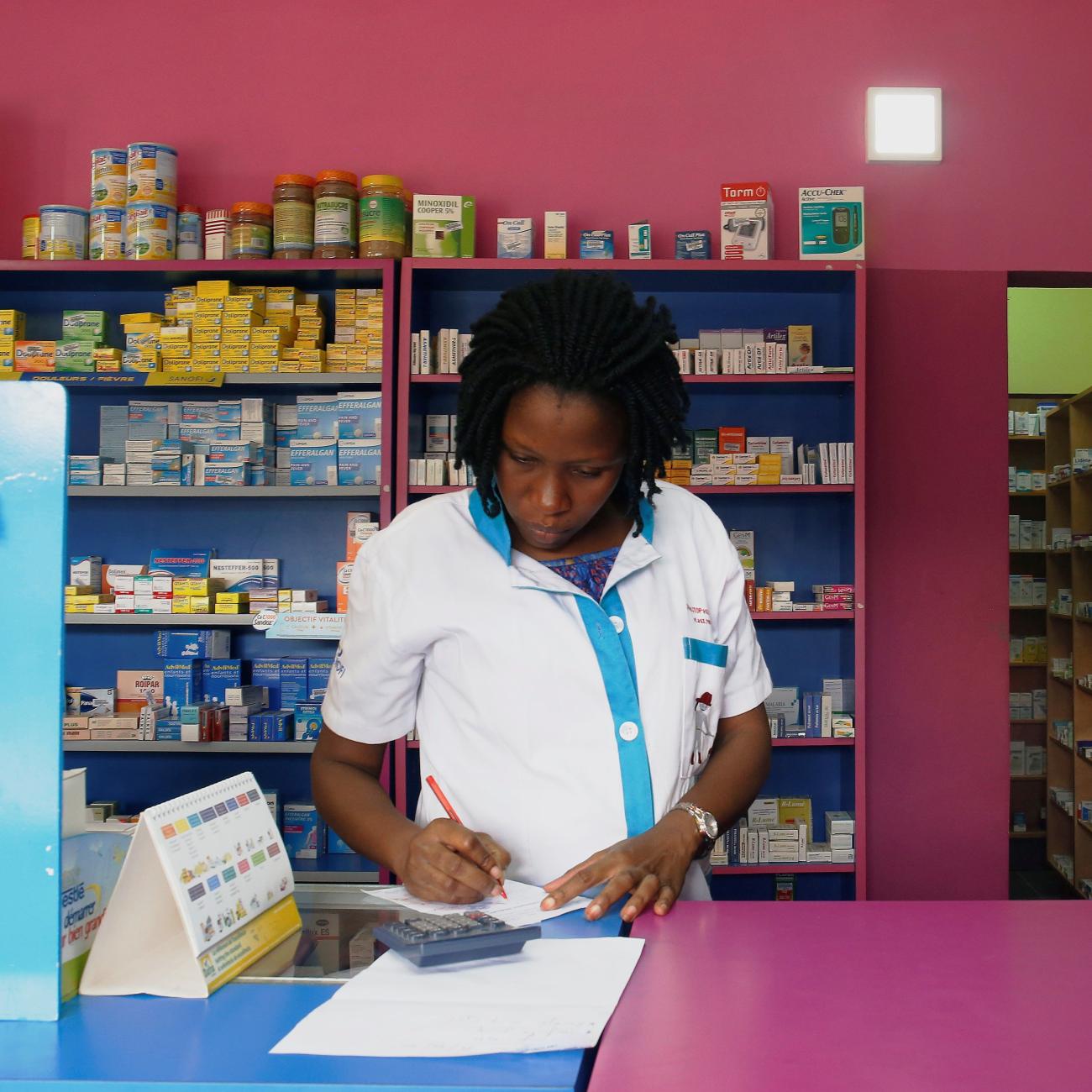 A vendor writes as she stands in a legal pharmacy, in Abidjan, Ivory Coast, on October 16, 2018. 