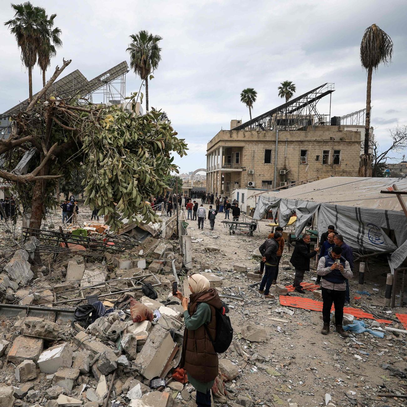 Palestinians inspect the damage after two Israeli missiles hit a building inside the Al-Ahli Arab Baptist Hospital, in the Gaza Strip, on April 13, 2025. 