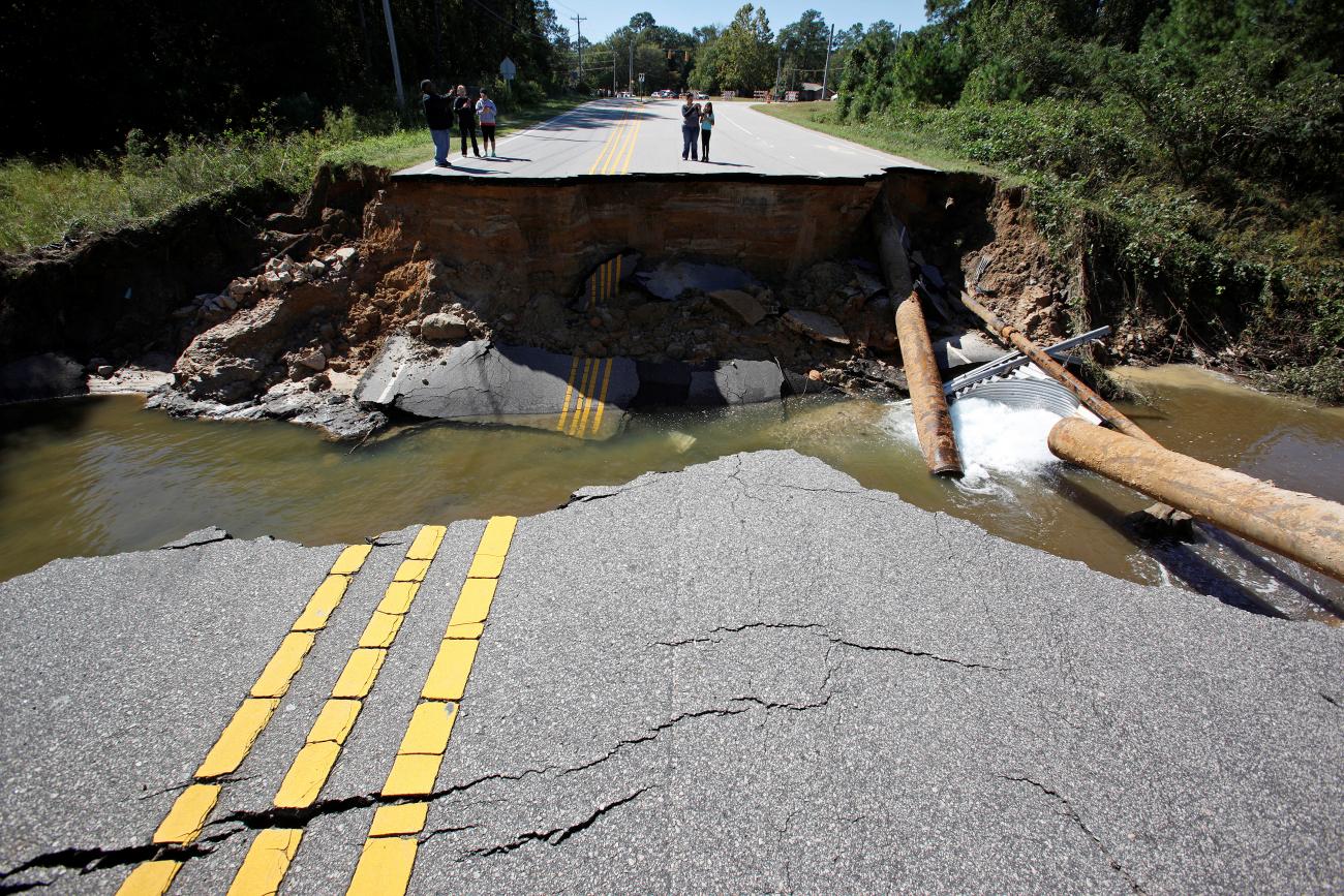 Residents inspect a washed-out section of collapsed road after Hurricane Matthew hit the state, in North Carolina.