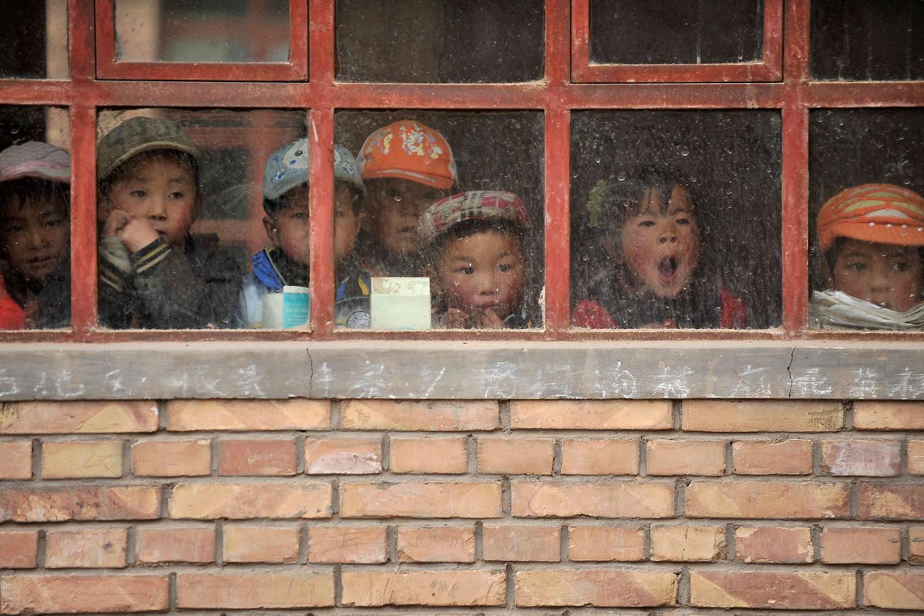 Children look out from their classroom in a (truly) rural primary school in Min County, Gansu Province, China on June 1, 2011. The school, with five teachers and 102 students, is on a high mountain. We see the adorable faces of several small children looking out weather-beaten window panes hung on a yellow brick wall. Faded chalk writing of chinese characters can be seen scribbled on the concrete sill. REUTERS photo.