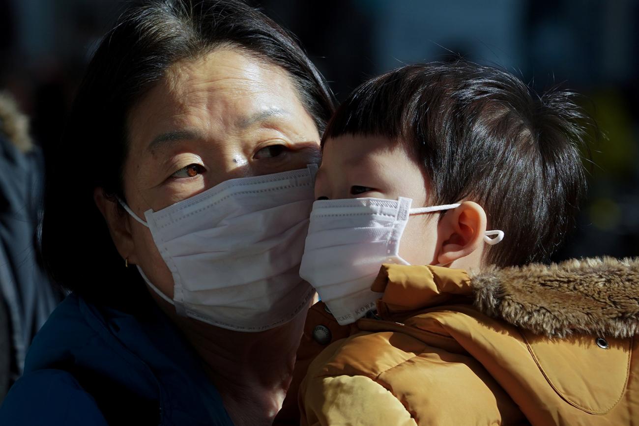 A mother and her child wear a mask to prevent contacting a new coronavirus in Seoul, South Korea, January 26, 2020. The photo shows the two face to face with each other, but their faces are covered almost completely below their eyes by the dust masks. REUTERS/Yonhap