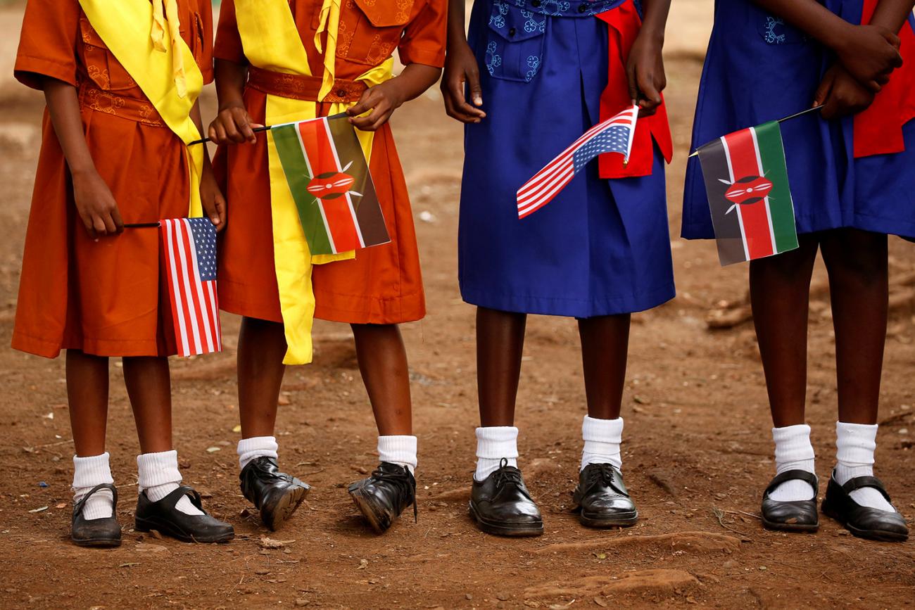 Young girls holding U.S. and Kenyan flags wait to greet U.S. Ambassador Robert Godec at a President's Emergency Plan for AIDS Relief (PEPFAR) project for girls' empowerment in Nairobi on Mar 10, 2018. The photo shows four girls from the stomach down holding flags. REUTERS/Jonathan Ernst 