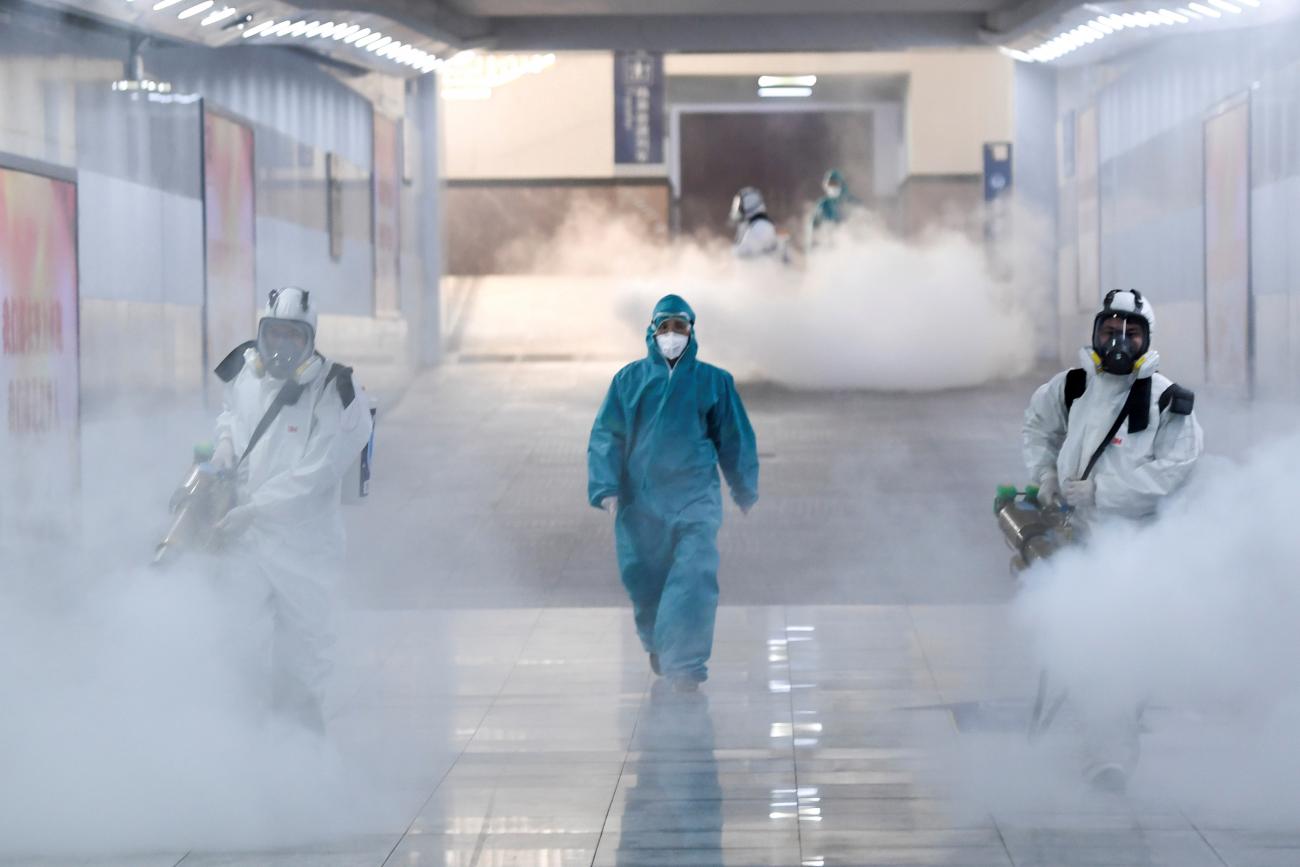 Volunteers in protective suits disinfect a railway station in Changsha, Hunan province, China, February 4. The photo shows several people clad head-to-toe in protective suits fogging what is presumably a disinfectant in thick clouds. REUTERS/cnsphoto