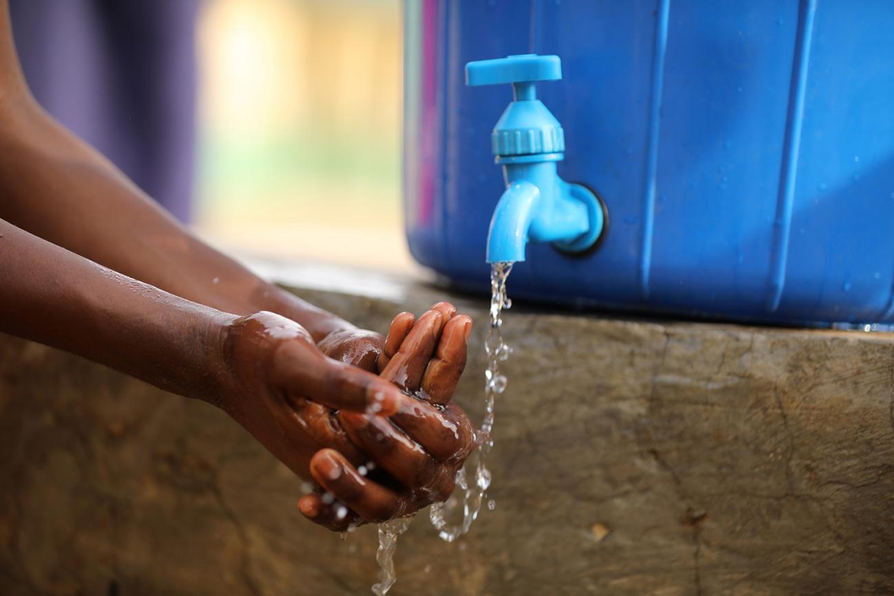 A student washes her hands after clean up at a school in response to the novel coronavirus pandemic in Abuja, Nigeria on March 20, 2020. The photo shows a pair of hands actively lathering under a water tap against a blue background. REUTERS/Afolabi Sotunde
