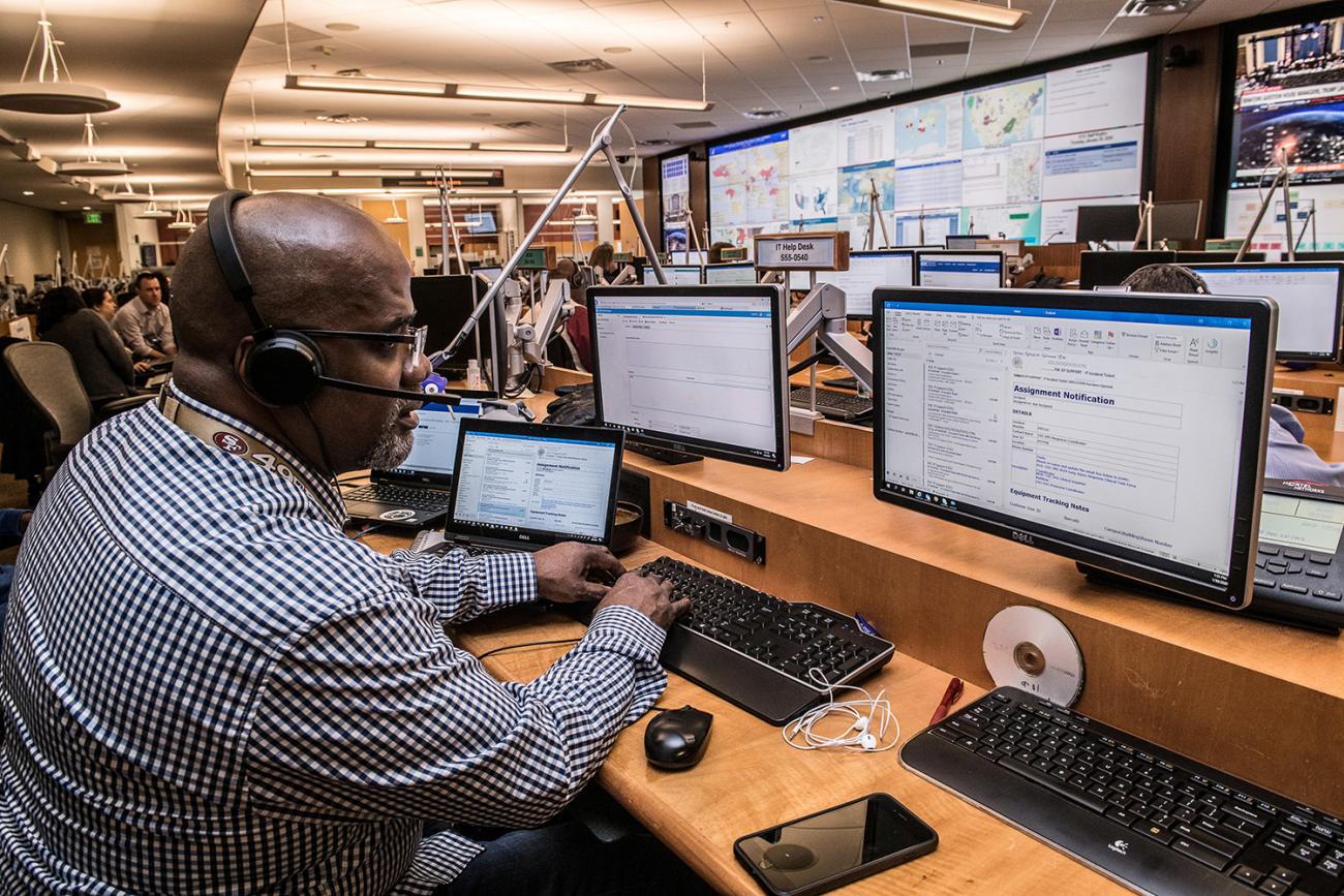 U.S. Centers for Disease Control and Prevention (CDC) staff support the COVID-19 novel coronavirus outbreak response in the CDC’s Emergency Operations Center in Atlanta, Georgia on March 10, 2020. Picture shows a man in a large operations room with numerous huge display screens showing data. CDC/James Gathany via REUTERS.