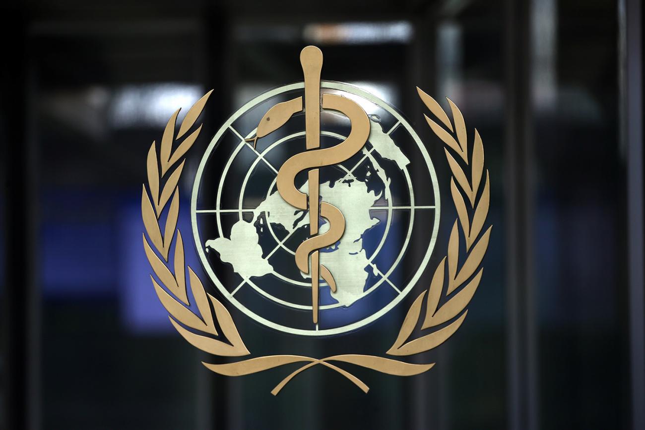 A logo is pictured on the headquarters of the World Health Organization (WHO) ahead of a meeting of the Emergency Committee on the novel coronavirus in Geneva, Switzerland on January 30, 2020. The photo shows a closeup of the logo on a dark background. REUTERS/Denis Balibouse