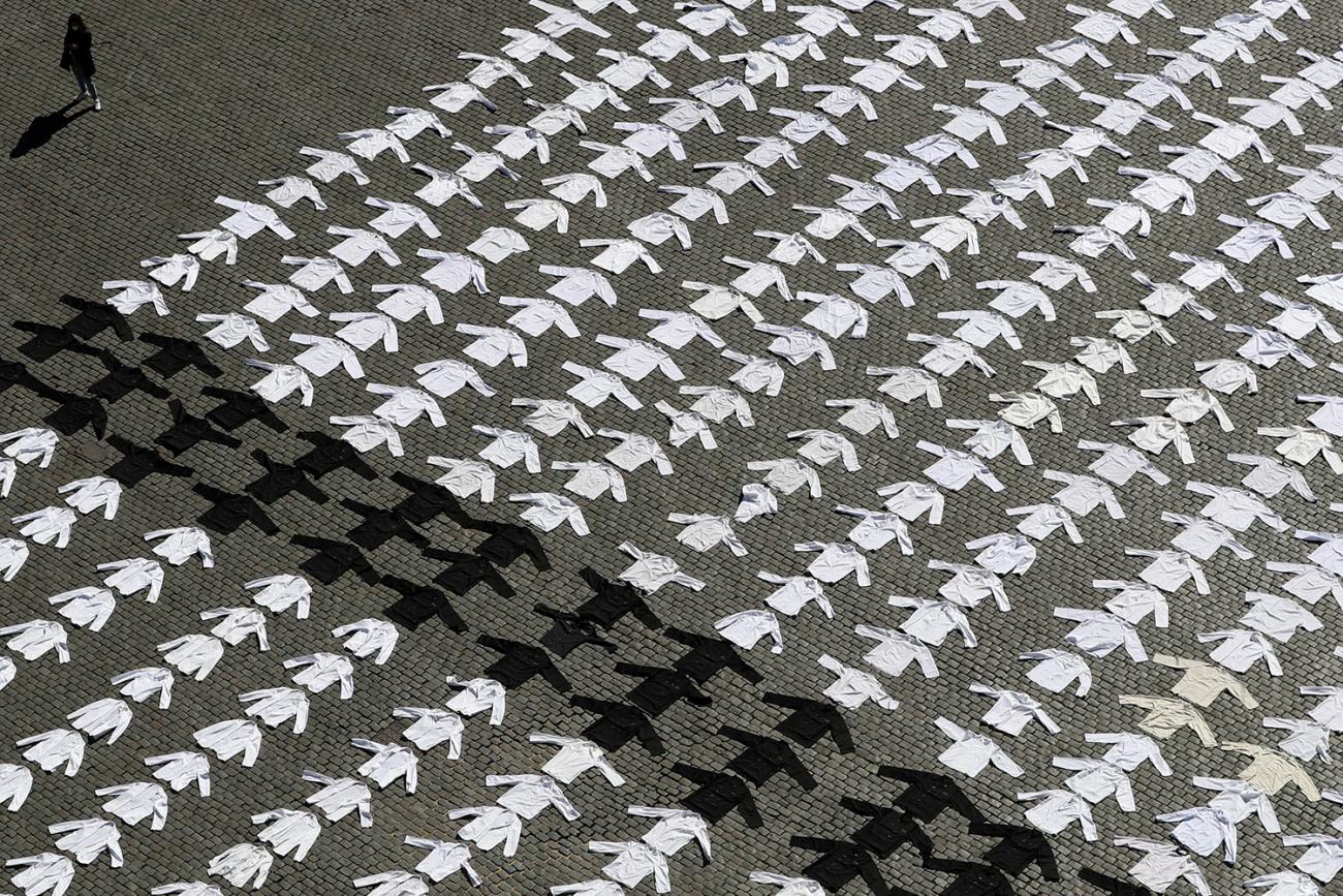 Cooking jackets are laid down and displayed as part of a COVID-19 protest by workers of the cafe and restaurant business demanding more help from the government in Brussels, Belgium, on May 7, 2020. The photo shows an array of shirts, mostly white but a few black ones, laid out over thousands of square feet of a lawn. It's a striking photo. REUTERS/Yves Herman