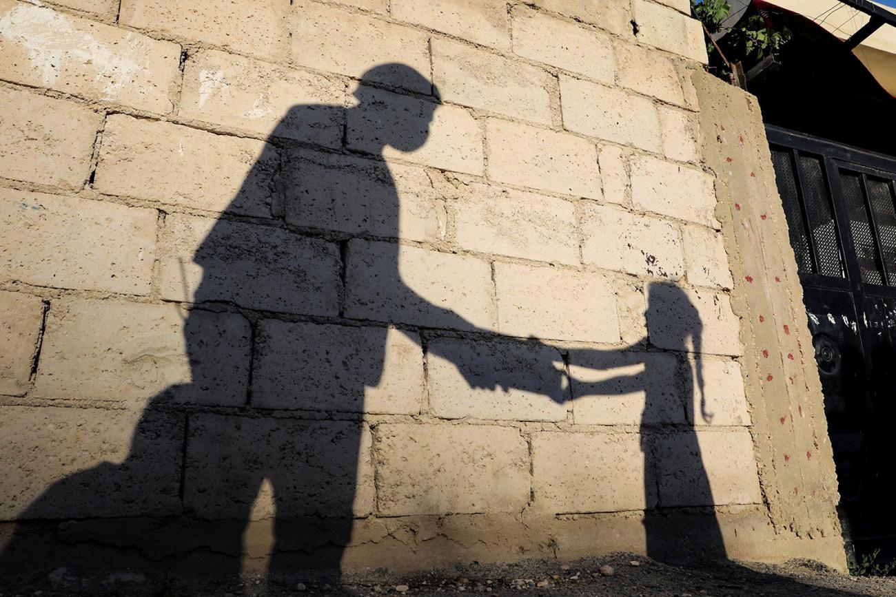 The shadow of a girl receiving an evening meal from a humanitarian service center is cast on a wall in front of her family home in Russeifa, Jordan, on April 28, 2020 during the coronavirus pandemic. Picture shows the girl's shadow on an old wall. REUTERS/Muhammad Hamed 