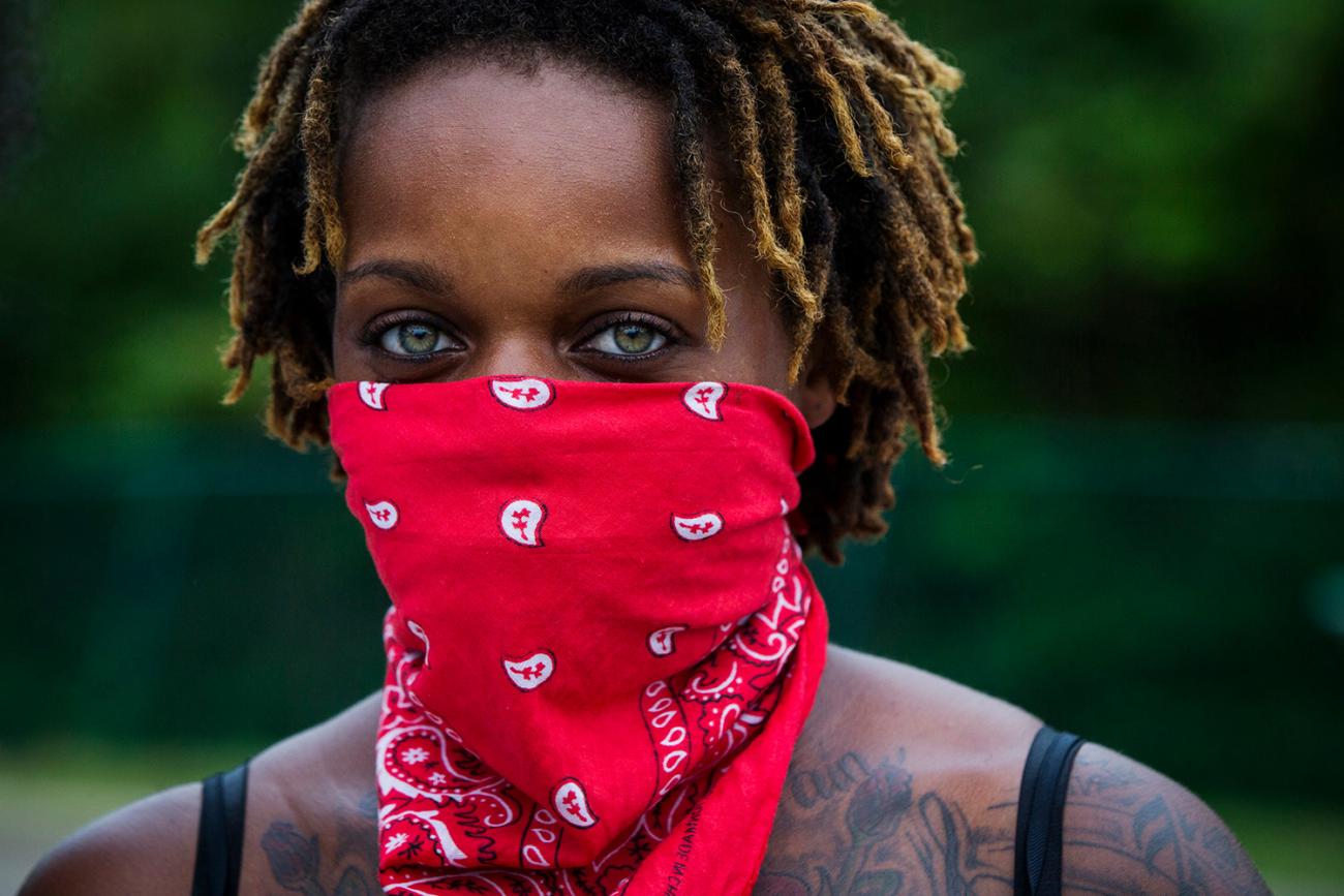 A woman looks into the camera during a demonstration to protest the shooting of Michael Brown and the resulting police response to protests in Ferguson, Missouri August 15, 2014. The photo shows a woman with a red bandana tied around her face. REUTERS/Lucas Jackson 