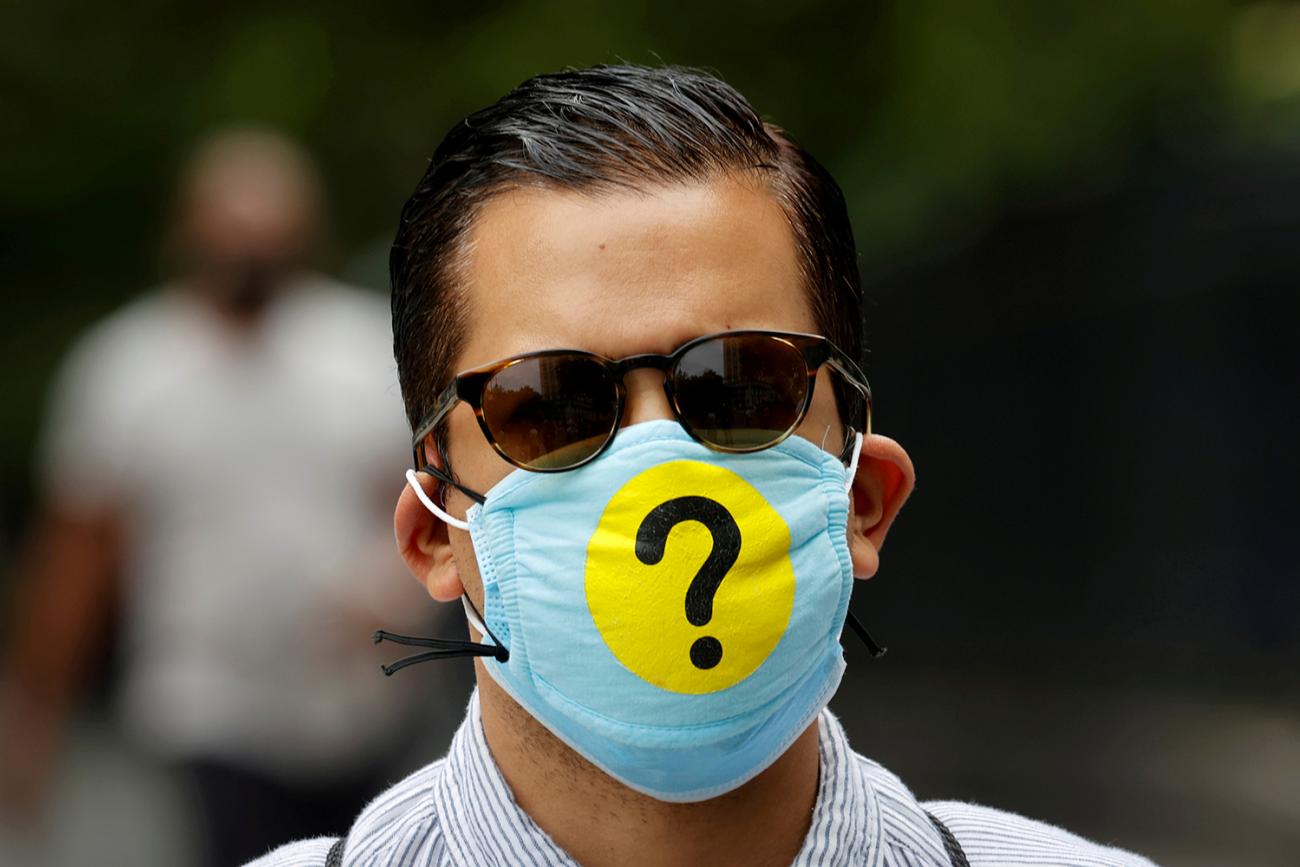 A man wears a protective facemask decorated with a question mark in lower Manhattan during the outbreak of the coronavirus disease (COVID-19) in New York, U.S., May 22, 2020. Picture shows a well groomed man who appears to be in his 30s wearing a mask adorned with a huge question mark. REUTERS/Mike Segar 