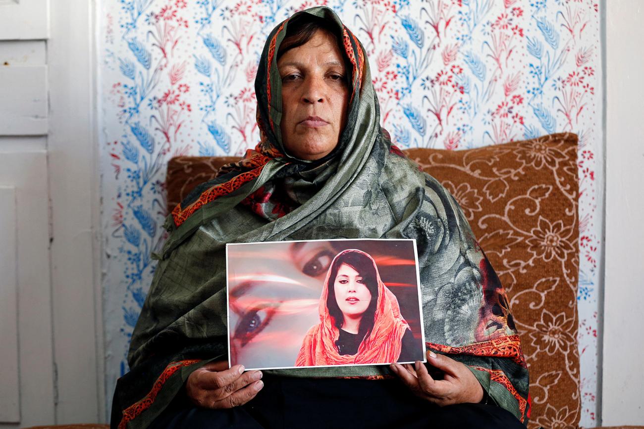 Anisa Mangal on May 14, 2019 holds a photo of her daughter Mena Mangal, an Afghan journalist, parliamentary adviser, and advocate of women's rights who was killed last year in Kabul, Afghanistan. Picture shows the mother stermly looking at the camera holding a photo of her daughter. REUTERS/Mohammad Ismail