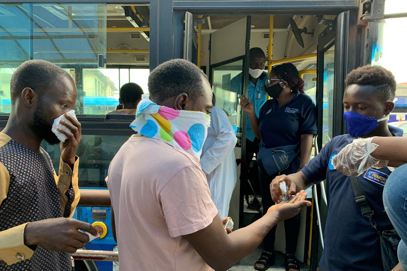 Public transport bus staff offers hand-sanitizer to a passenger who is about to board the bus on the first day of the easing of the lockdown measures during the outbreak of the coronavirus disease (COVID-19) in Lagos, Nigeria May 4, 2020. The photo shows a bus driver dispensing sanitizer to passengers as they board. REUTERS/Temilade Adelaja