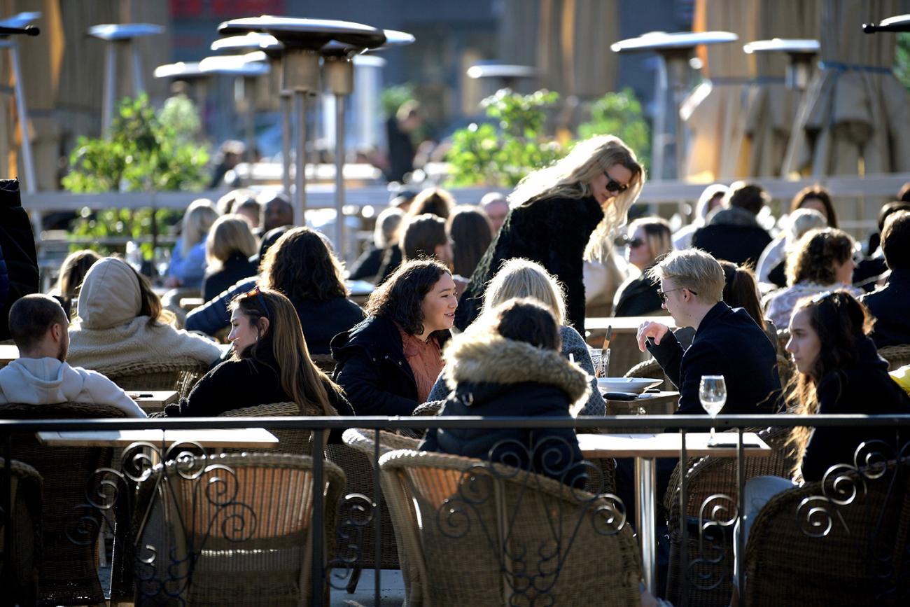 People enjoy the sun at an outdoor restaurant, despite the continuing spread of the coronavirus disease (COVID-19), in Stockholm, Sweden March 26, 2020. The photo shows a large number of people sitting lose together in an outdoor eating area. TT News Agency/Janerik Henriksson via REUTERS
