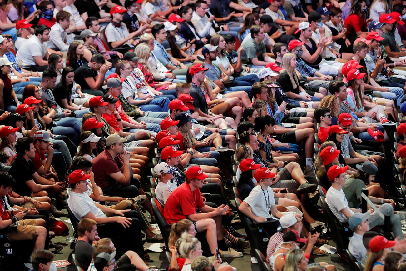 Ignoring the science on social distancing, not congregating indoors, and wearing masks, young people listen to U.S. President Donald J. Trump at the Dream City Church in Phoenix on June 23, 2020. The photo shows a huge crowd of yound people, very few wearing masks, packed into theater-like seats. REUTERS/Carlos Barria