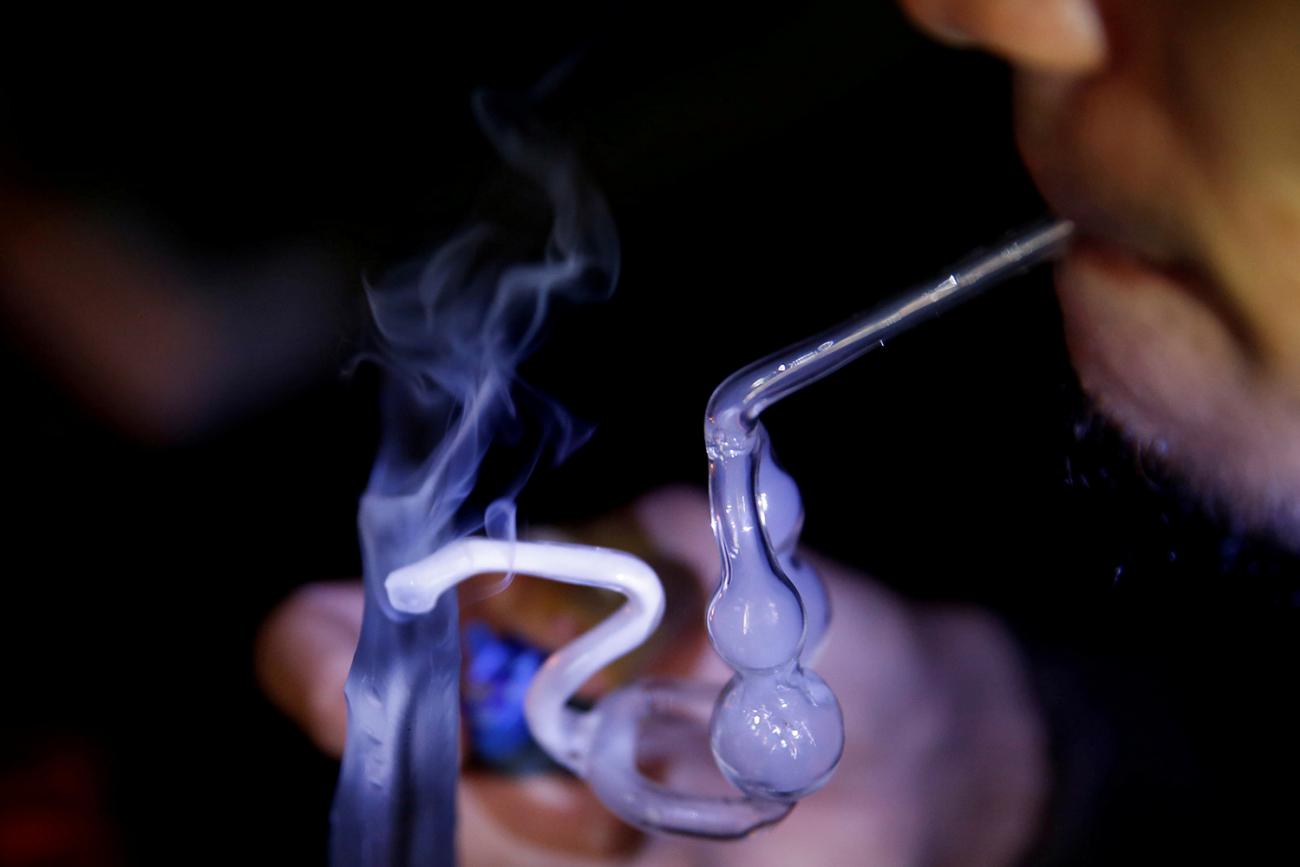 A drug addict uses a glass water pipe to smoke methamphetamine at an undisclosed drug den in Manila, Philippines, on June 20, 2016. The photo is a closeup of a man smoking from a glass pipe. REUTERS/Staff/File Photo