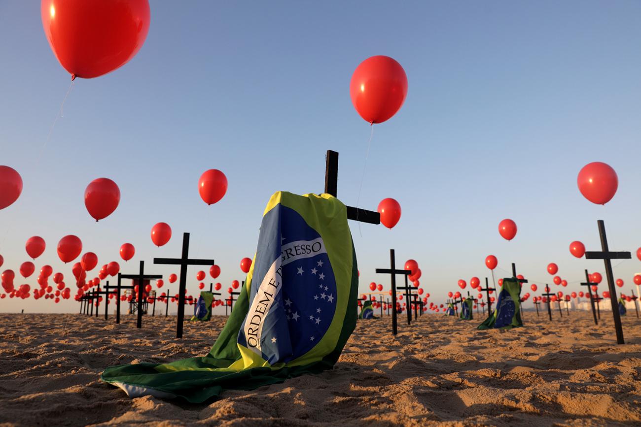 Global health security seeks to avoid installations like this one of crosses and balloons at Copacabana beach in Rio de Janeiro, Brazil, on August 8, 2020—a tribute to 100,000 victims of coronavirus. The photo shows an art installation of crosses, balloons and flag on the beach. REUTERS/Ricardo Moraes