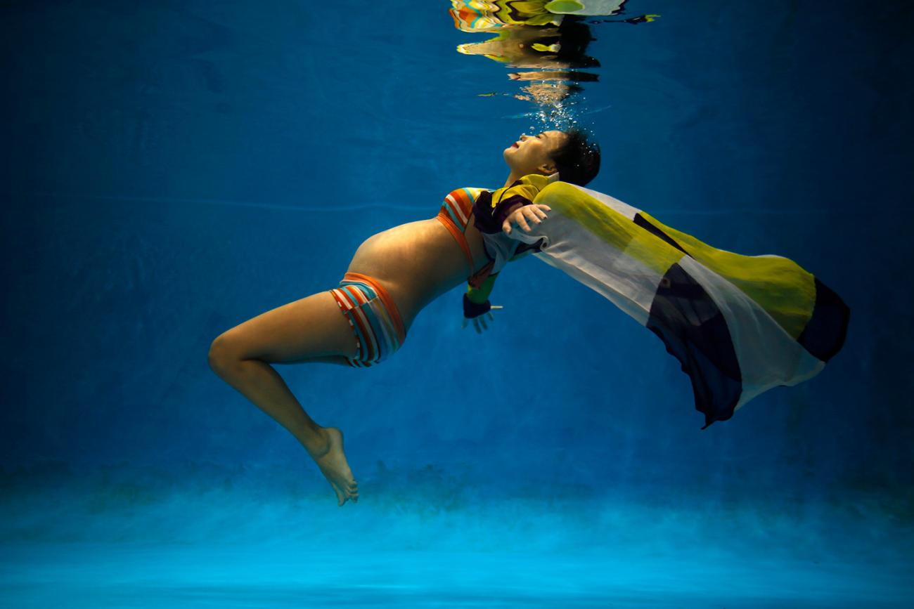 Jiejin Qiu, six months pregnant with her first baby, poses underwater during a photo shoot at a local wedding photo studio in Shanghai on September 5, 2014—as China began easing its one-child policy. The photo shows the expecting mother floating underwater in a dream-like shot. REUTERS/Carlos Barria 
