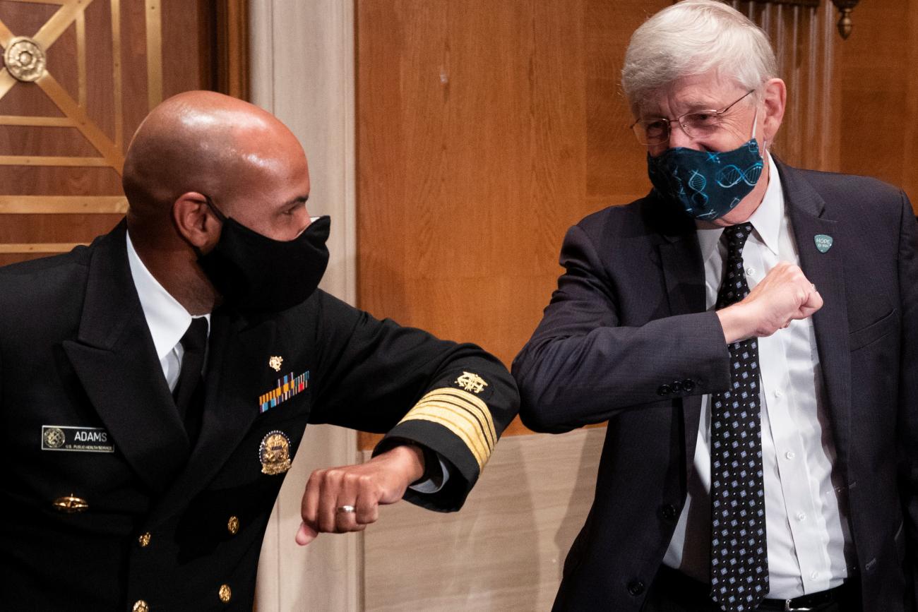 U.S. Surgeon General Jerome Adams and National Institutes of Health (NIH) Director Francis Collins bump elbows after testifying before the Senate Health, Education, Labor and Pensions Committee hearing to discuss about vaccines and protecting public health during the coronavirus disease (COVID-19) pandemic, in Washington, U.S., September 9, 2020.