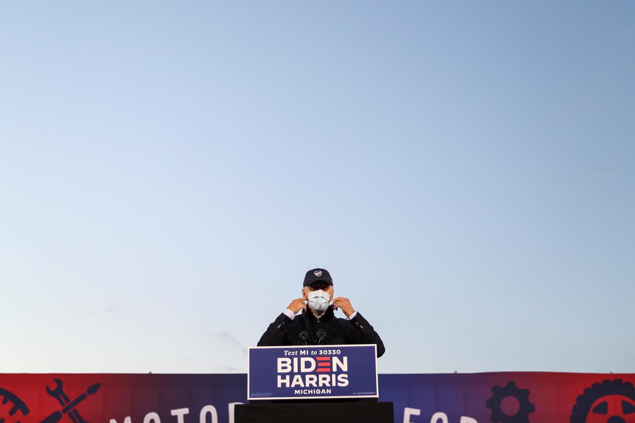 U.S. President-elect Joseph R. Biden prepares to remove his face mask to deliver remarks during a voter mobilization event at the Michigan State Fairgrounds in Novi, Michigan on October 16, 2020. 