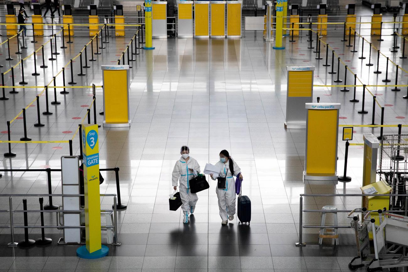 Passengers wearing hazmat suits for protection against the coronavirus disease walk inside the Ninoy Aquino International Airport in Paranaque, Metro Manila, Philippines on January 14, 2021.