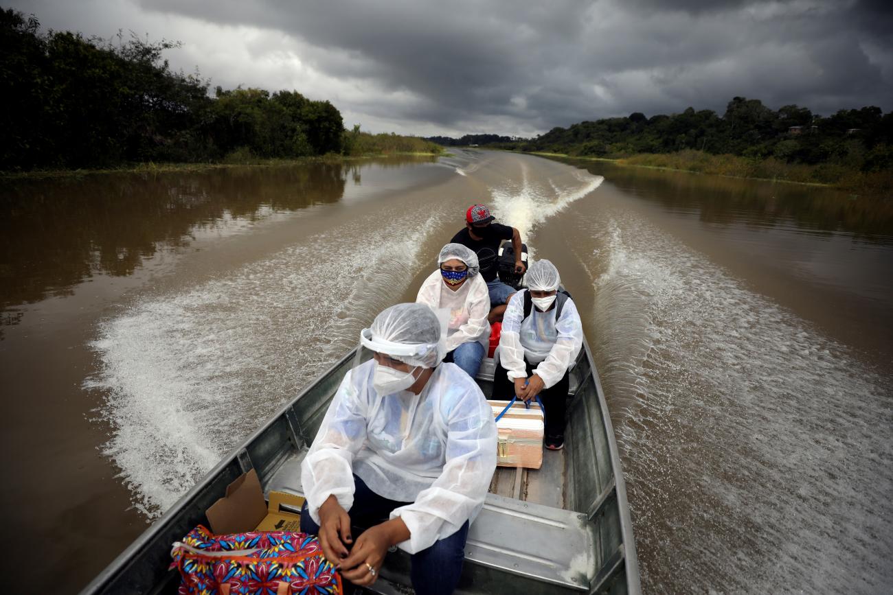 Municipal health workers travel on a boat along the Solimoes river banks to administer the Oxford-AstraZeneca coronavirus vaccine in Manacapuru, Amazonas state, Brazil on February 1, 2021.