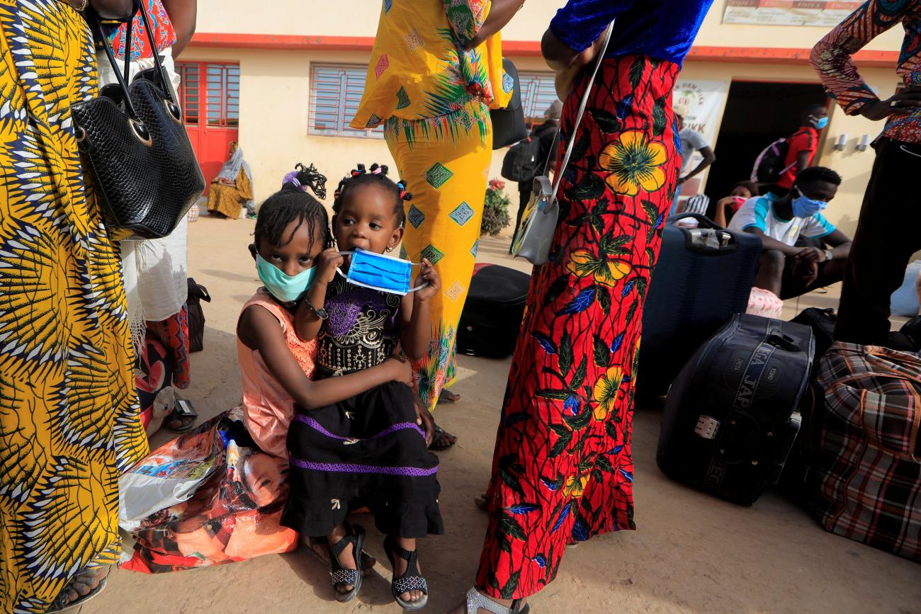 Teachers and their children wait to board a government chartered bus bringing people back to schools of countryside towns in Dakar, Senegal on May 28, 2020.