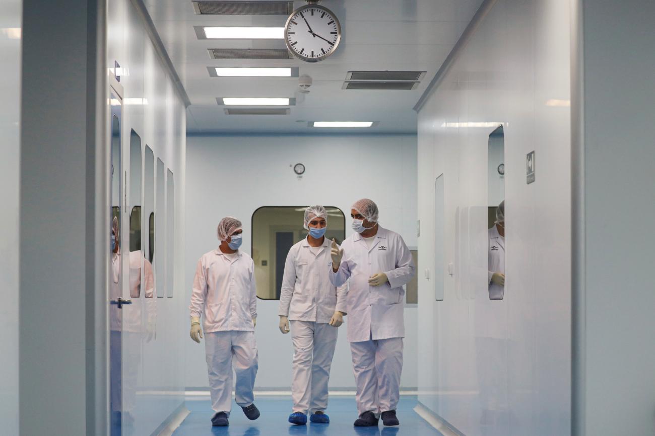 Lab technicians walk as they work on investigational coronavirus disease (COVID-19) treatment drug "Remdesivir" at Eva Pharma Facility in Cairo, Egypt June 25, 2020.