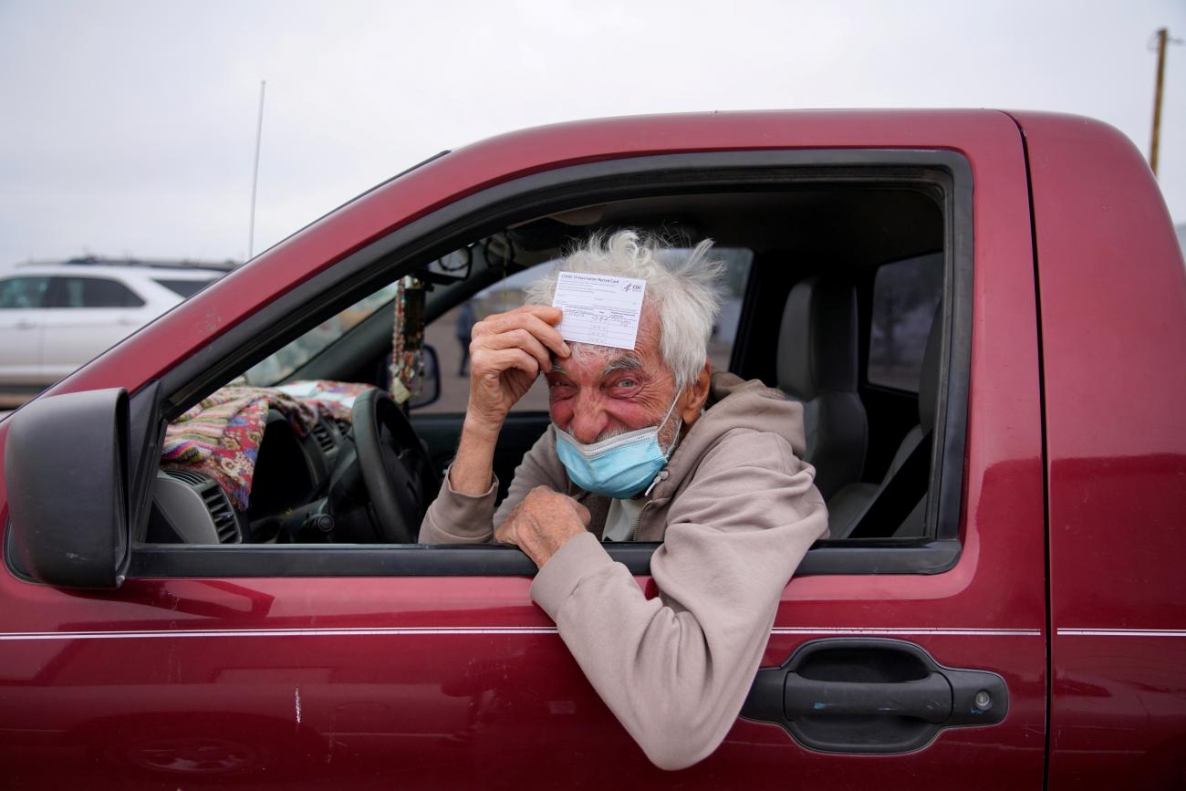 poses for a portrait with his vaccination card after receiving his coronavirus disease (COVID-19) vaccine at a rural vaccination site in Columbus, New Mexico, U.S., April 16, 2021. 