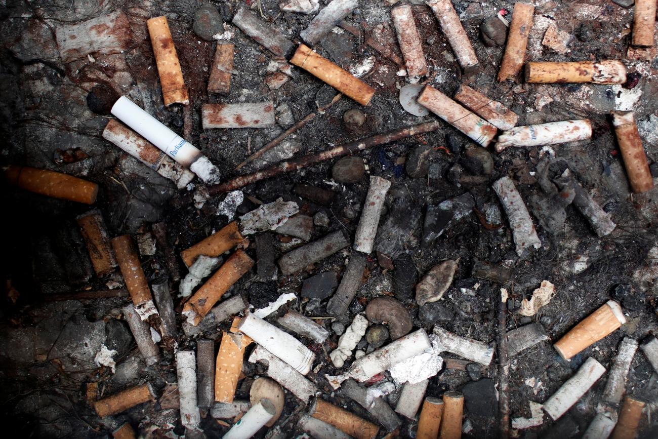 Discarded cigarette butts are seen beneath a sidewalk grating in Manhattan in New York City, May 8, 2017. 