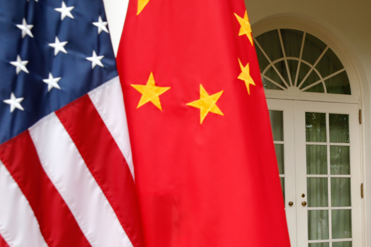 A close-up photo of the U.S. and Chinese flags hanging gently from poles at the White House in 2015.