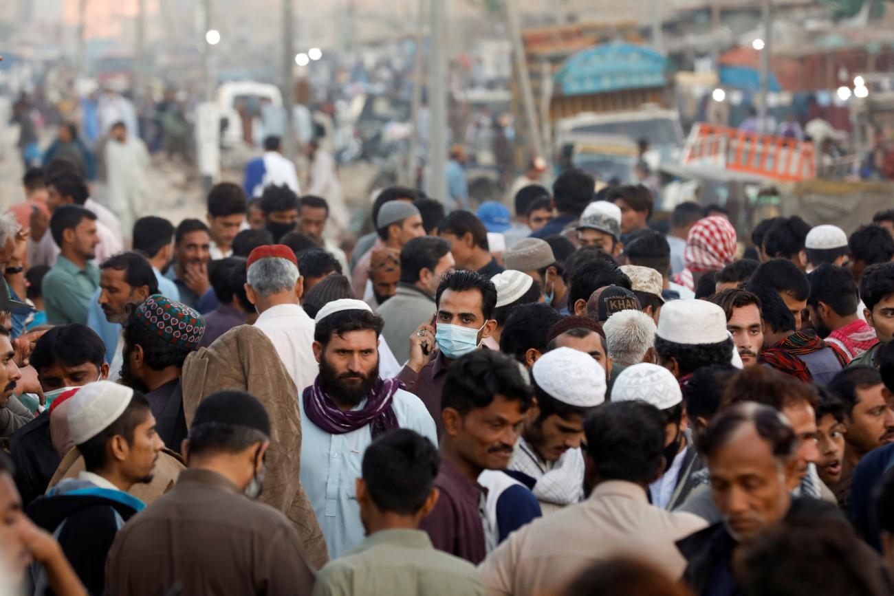 A man wearing a protective mask walks through a crowd of people along a makeshift market as the outbreak of the coronavirus disease (COVID-19) continues, in Karachi, Pakistan January 17, 2021