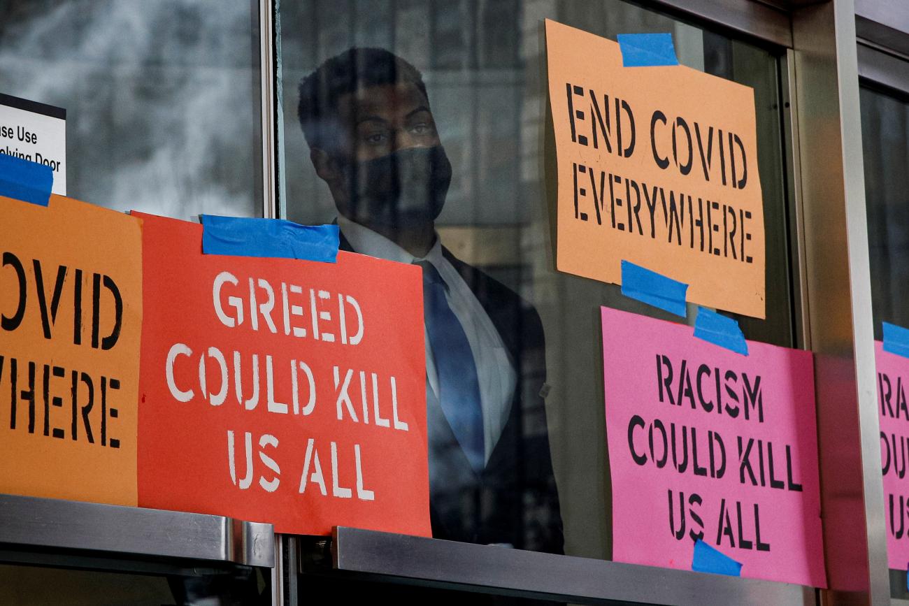 A security person looks out from the entrance to the Pfizer World Headquarters as activists rally for global access to the COVID-19 vaccine, in New York, July 14, 2021. 