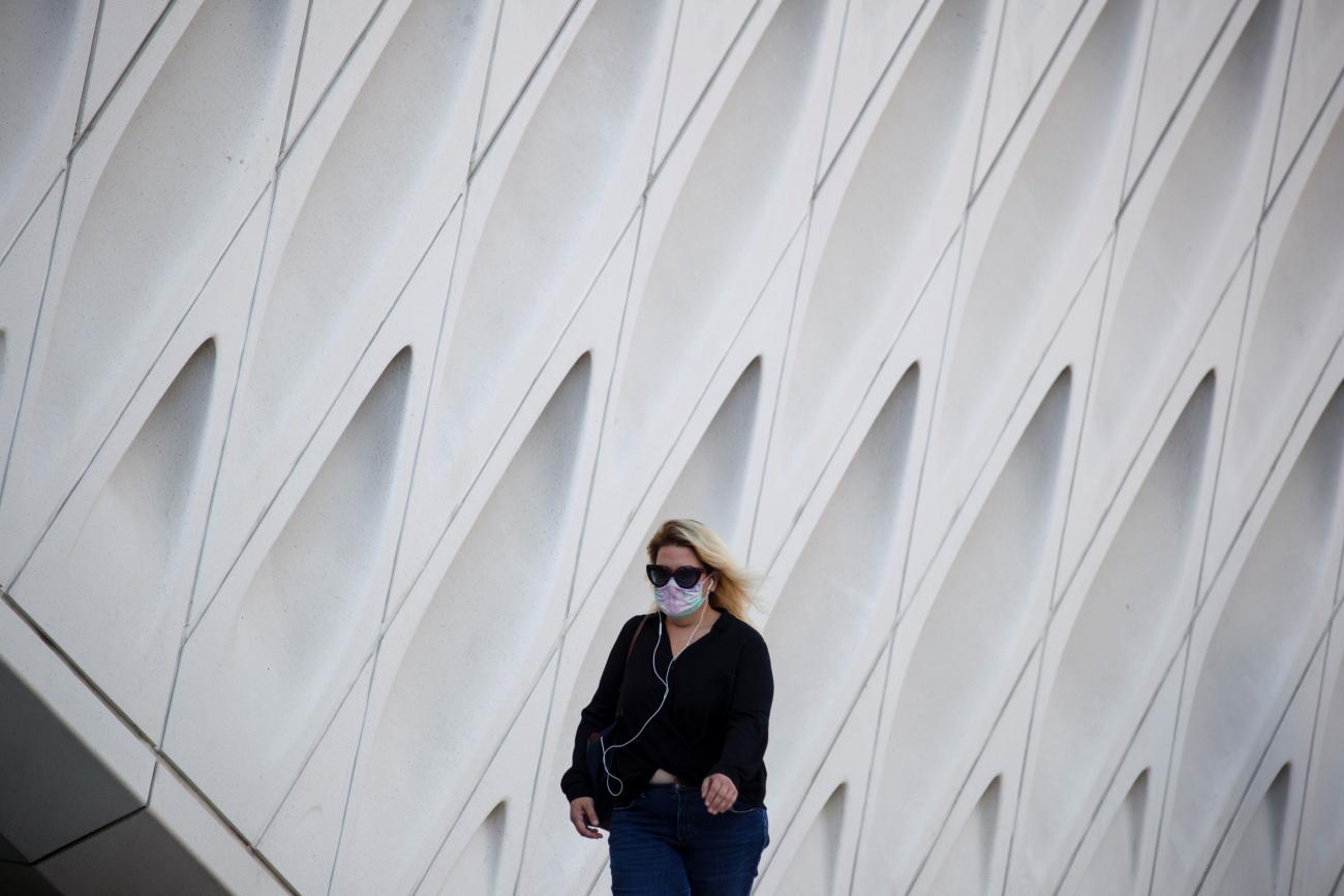 A woman wearing a face mask walks by The Broad Museum in downtown during the outbreak of the coronavirus disease (COVID-19), in Los Angeles, California, U.S., August 13, 2020.