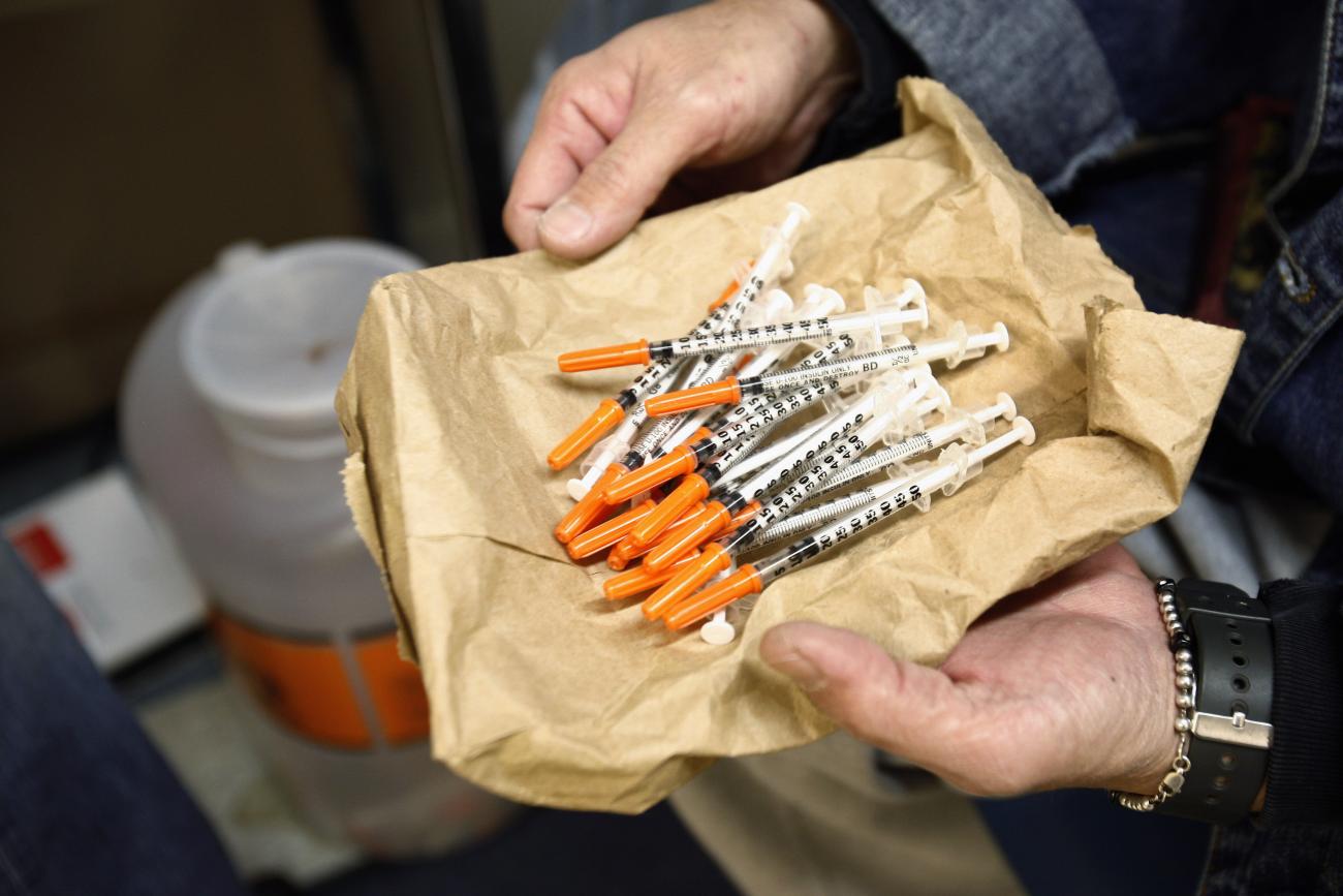 A woman shows her clean syringes at the Aids Center of Queens County needle exchange outreach center in New York, November 28, 2006. Participants bring used syringes to the program, and trade them for clean ones.