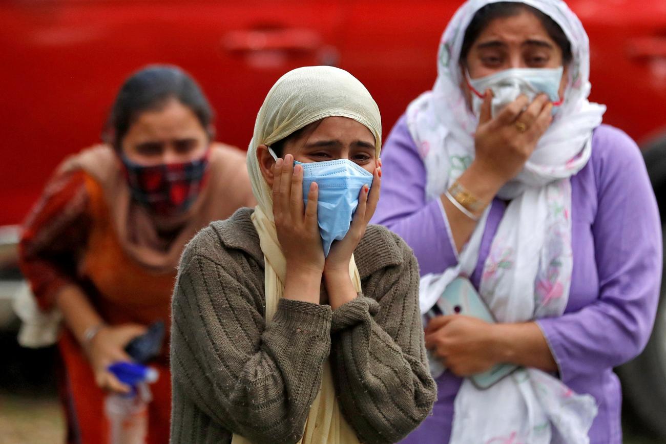 Relatives of a man who died from the coronavirus disease (COVID-19) mourn during his cremation at a crematorium ground in Srinagar May 25, 2021.