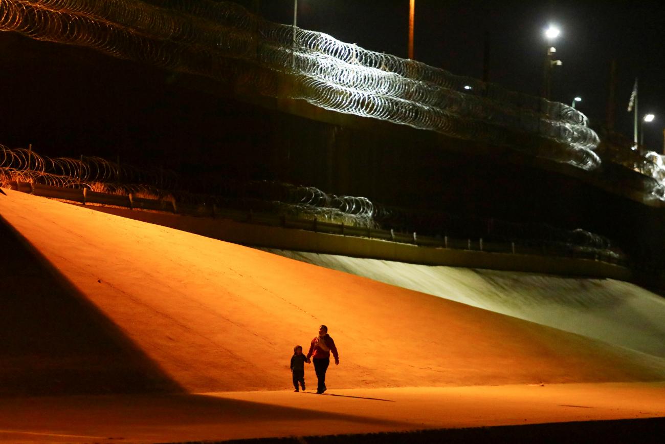 A mother and her son walk after crossing the Rio Bravo river to turn themselves in to U.S Border Patrol agents to request for asylum in El Paso, Texas, U.S.,as seen from Ciudad Juarez, Mexico.