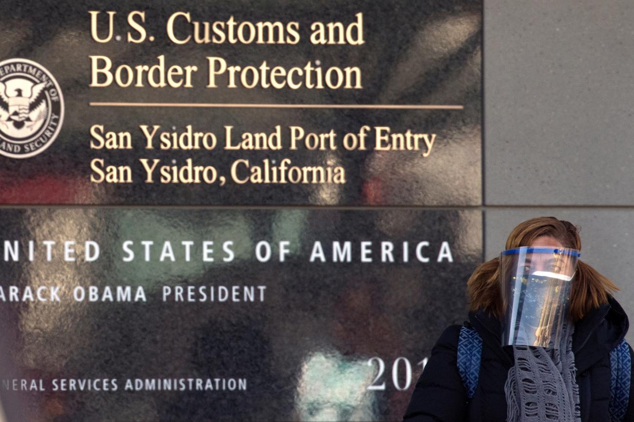 A traveler wearing a face shield and face mask arrives into the United States through the pedestrian entry at the San Ysidro - Tijuana, Mexico, border crossing during the outbreak of the coronavirus disease, in San Diego, California, U.S., December 2, 2020. 