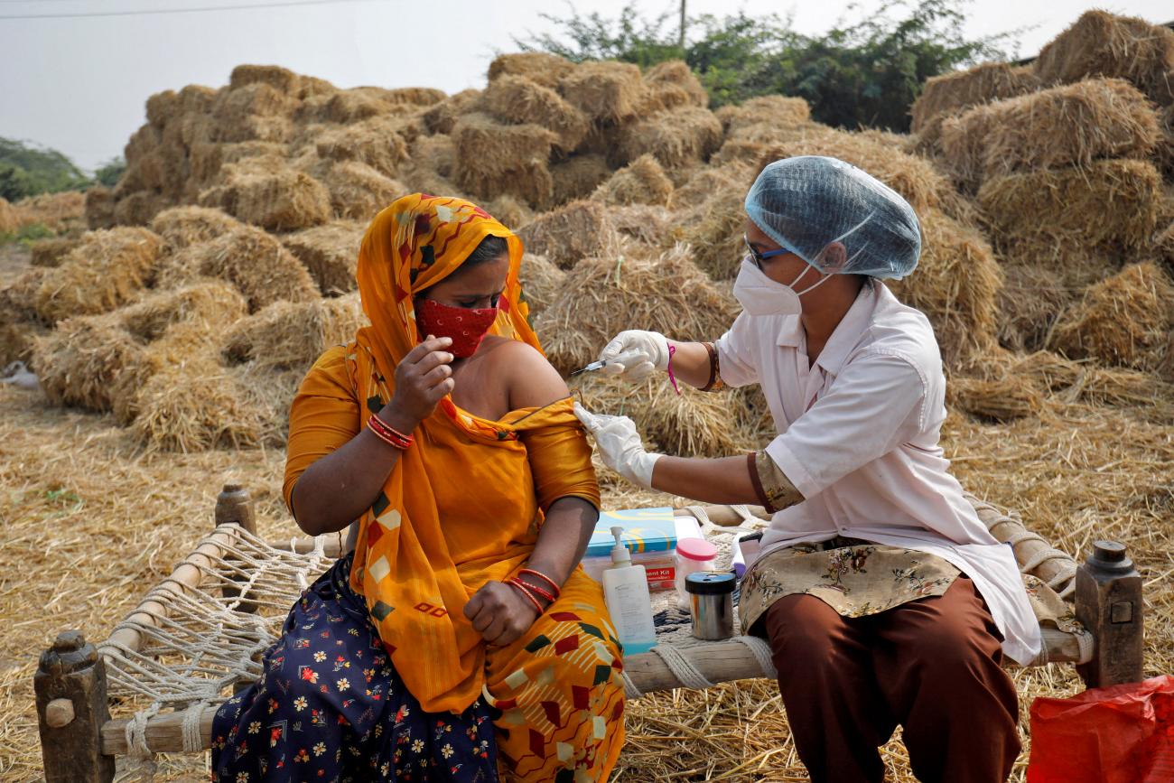 Jabuben Bharwad, 30, receives a dose of COVISHIELD vaccine against COVID-19, that's manufactured by Serum Institute of India, while working in a field during a door-to-door vaccination drive at Mahijada village on the outskirts of Ahmedabad, India, December 15, 2021